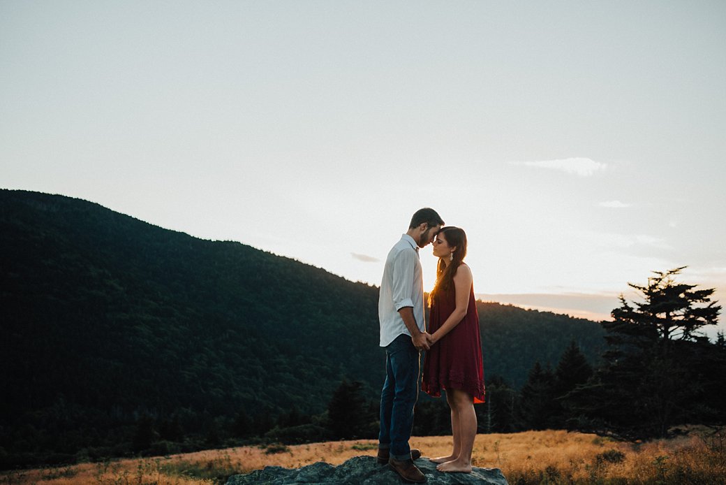 Tyler and Kailtyn standing face to face on rock for Roan Mountain Engagement Session 