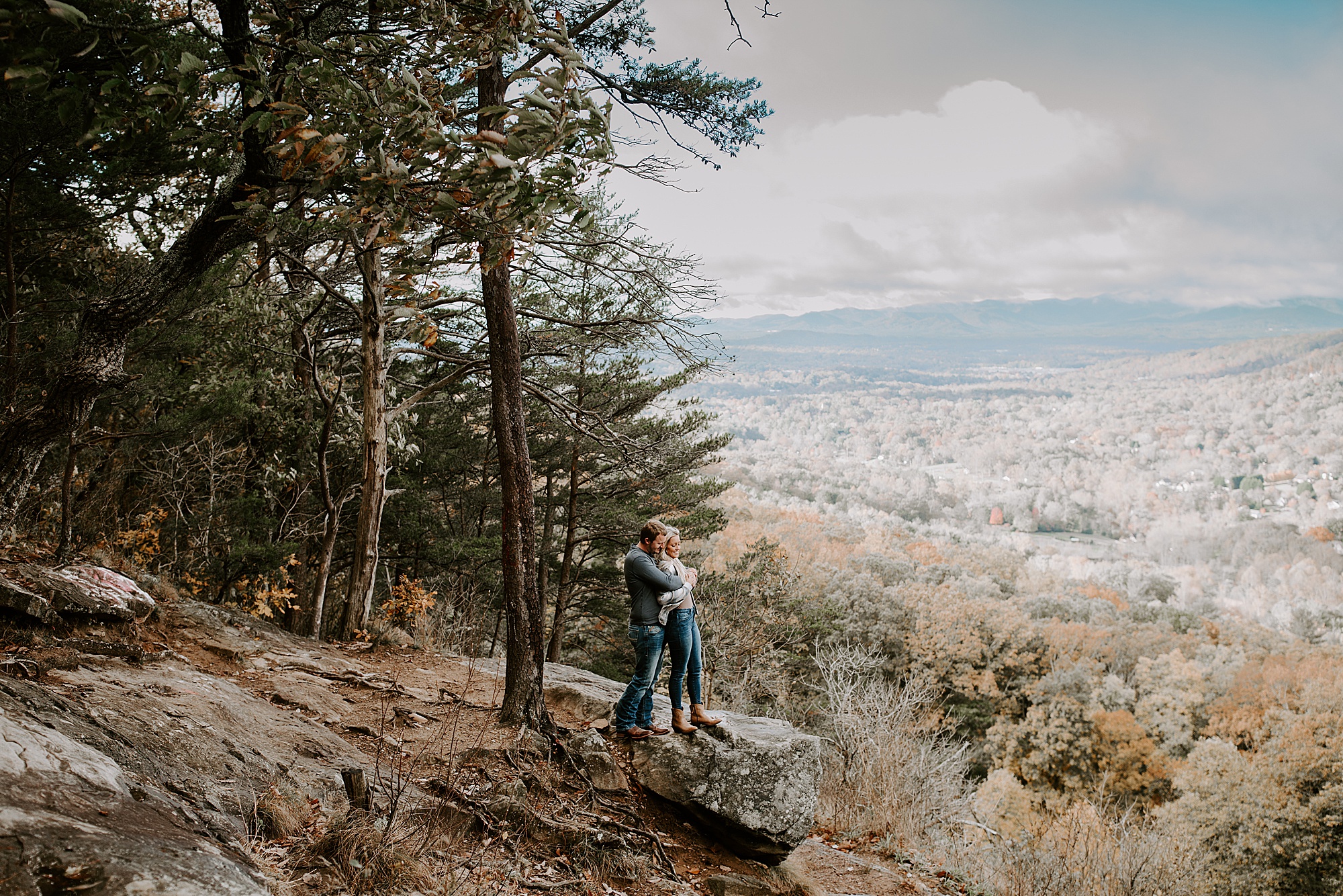 guy hugging girl from behind at haw creek valley overlook engagement session
