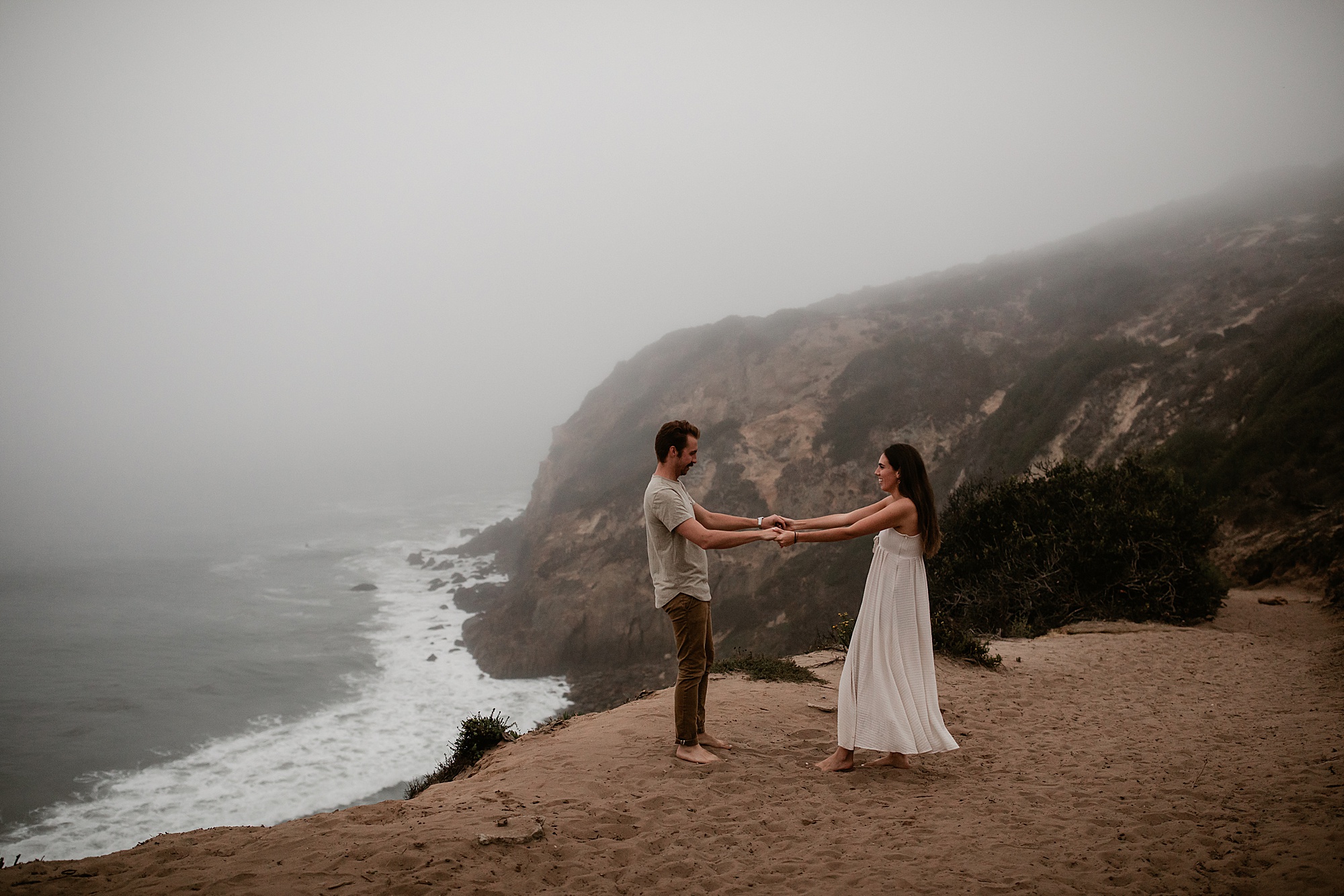 guy and girl dancing with point dume in the background malibu california beach photography